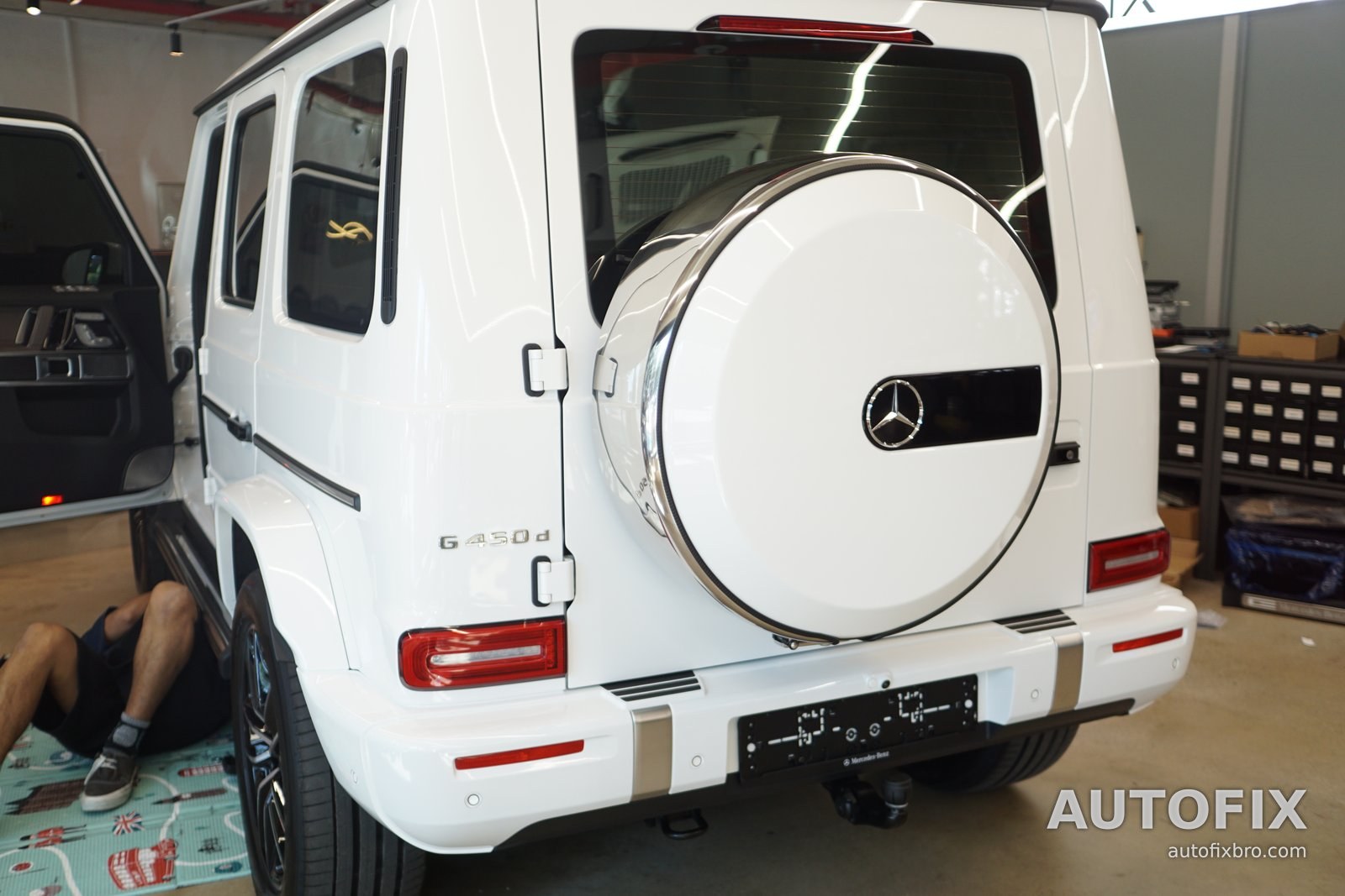 벤츠 G클래스 G450d (화이트) 뒤에서 본 모습. 차 아래로 들어가 사이드스텝 장착 위치를 확인하는 중입